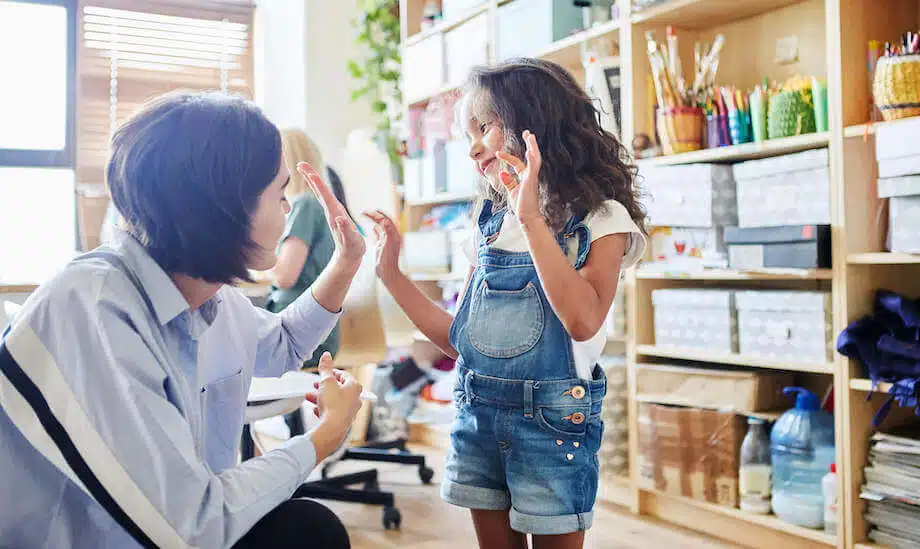 A teacher high-fiving a student, a simple example of positive reinforcement in the classroom