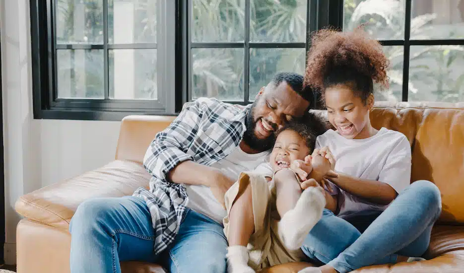Dad laughing and smiling with kids to create a loving environment for his kids.